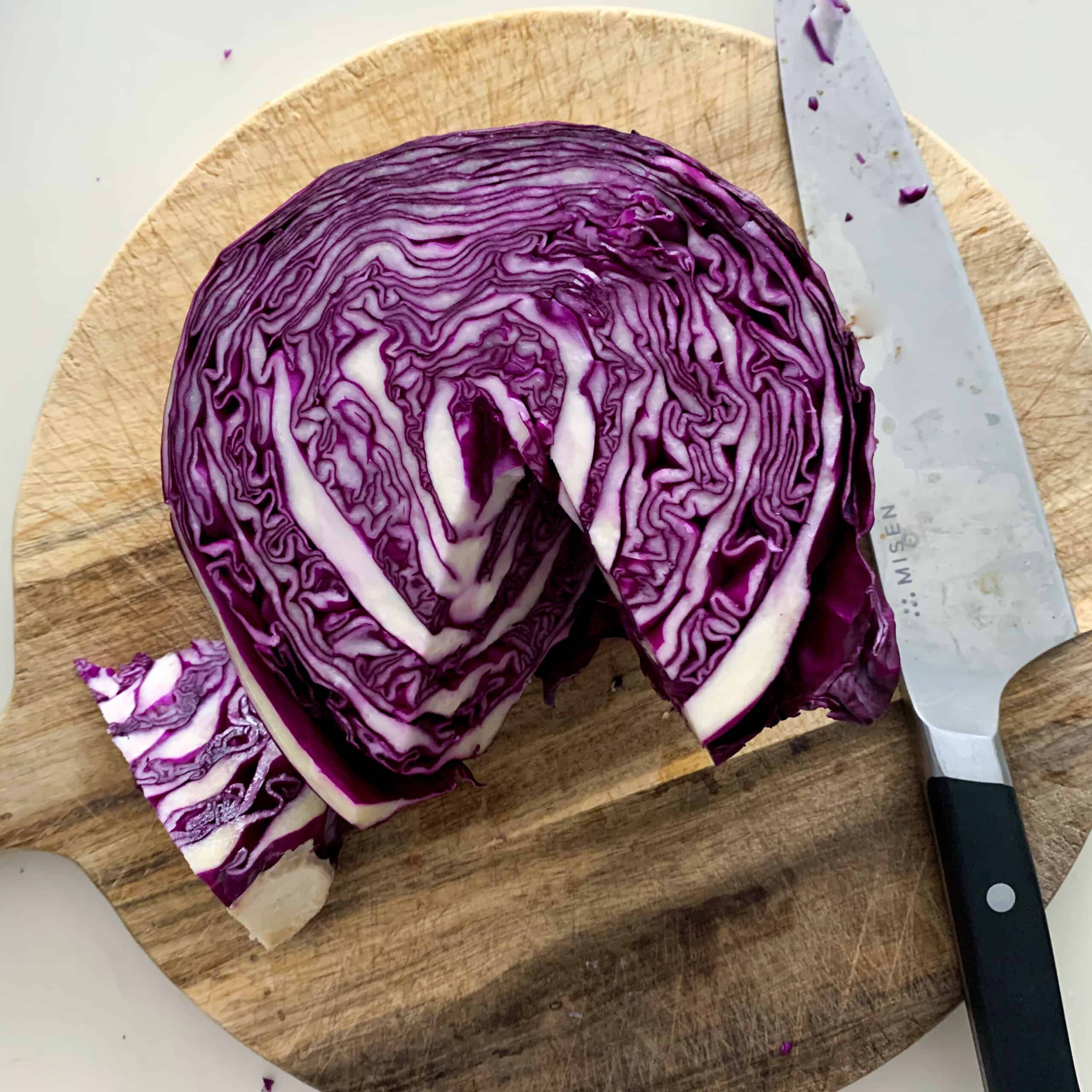 cored red cabbage on wooden board
