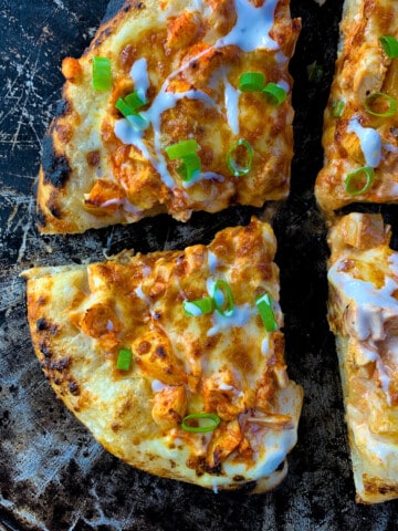 small buffalo chicken pizza cut in 4 slices on pizza pan