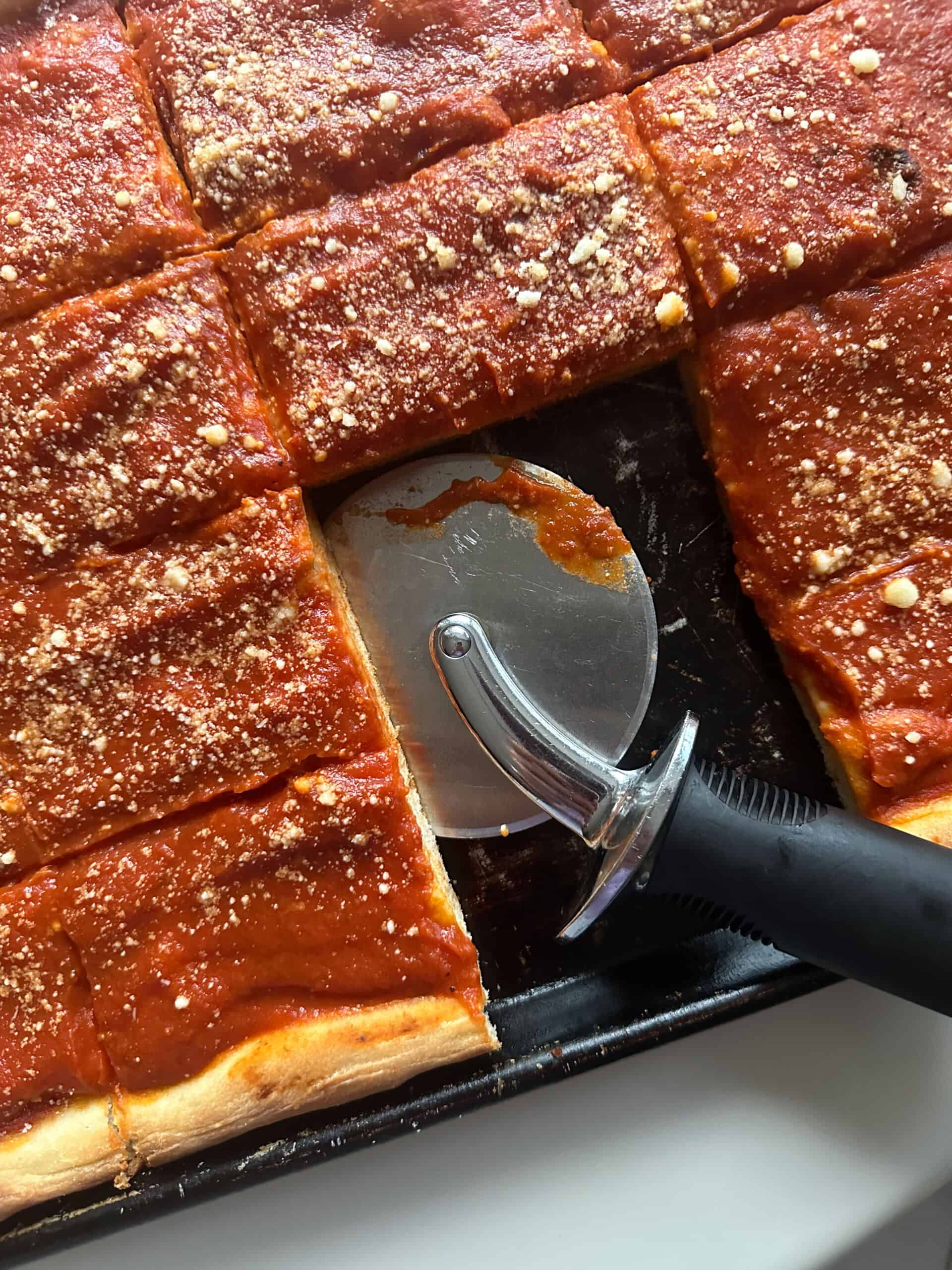 sliced tomato pie pizza with pizza cutter and slices missing