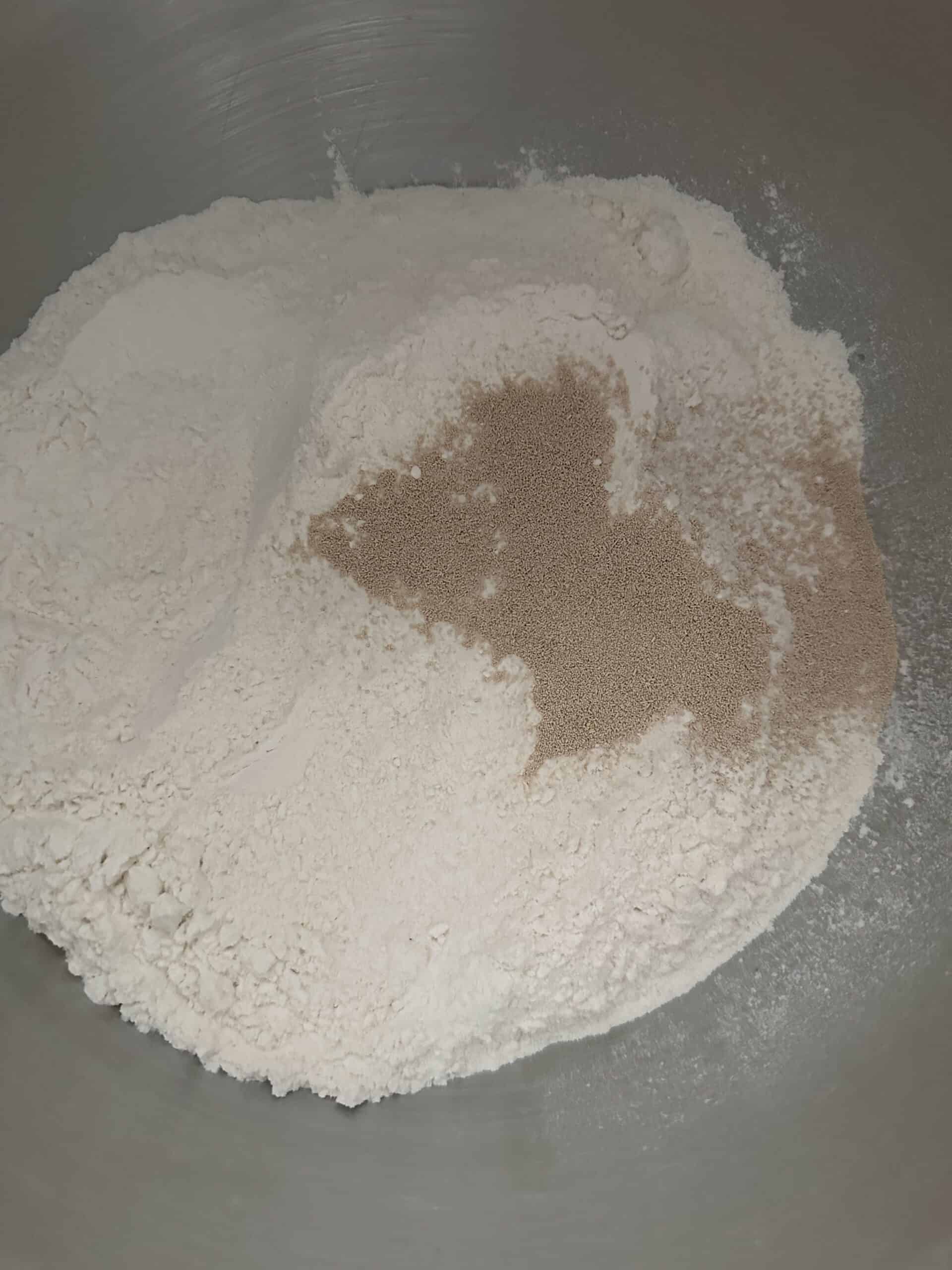 Flour yeast and sugar in mixing bowl