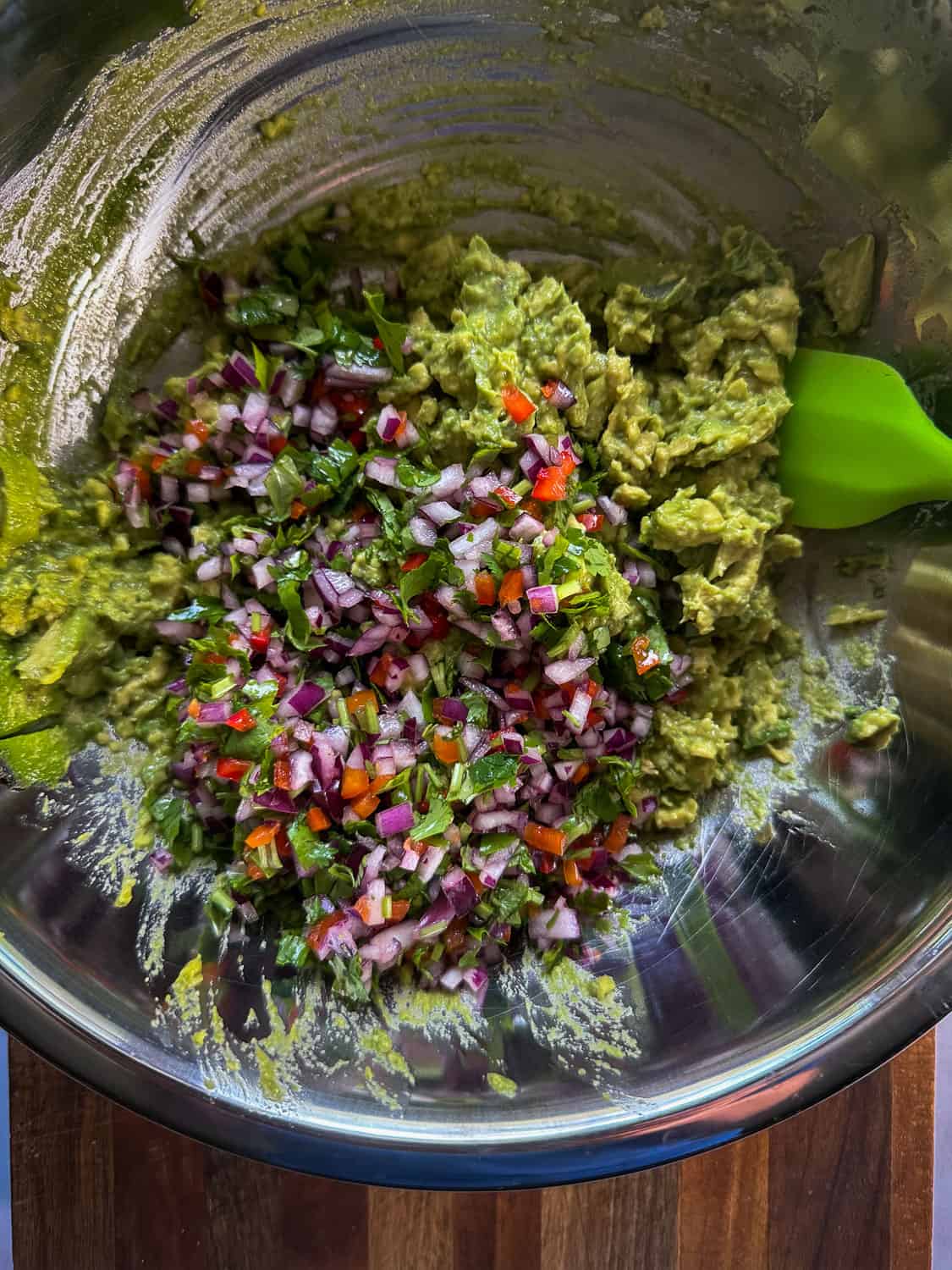 Guacamole ingredients in large bowl ready to be folded together