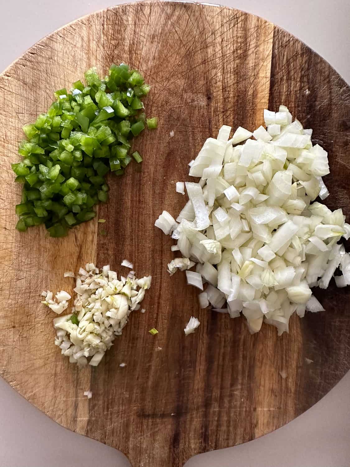 chopped onion, garlic, and jalapeno on wooden board