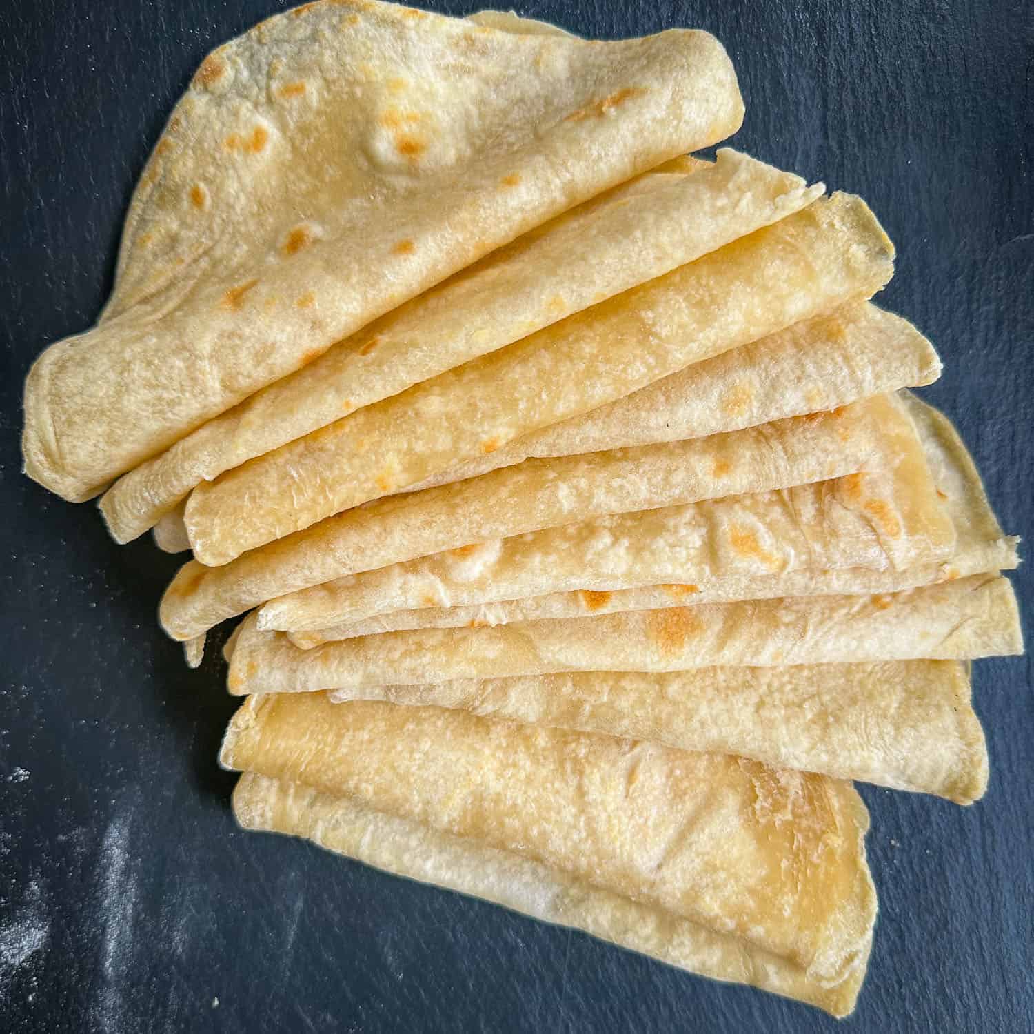 soft flour homemade tortillas on black tray