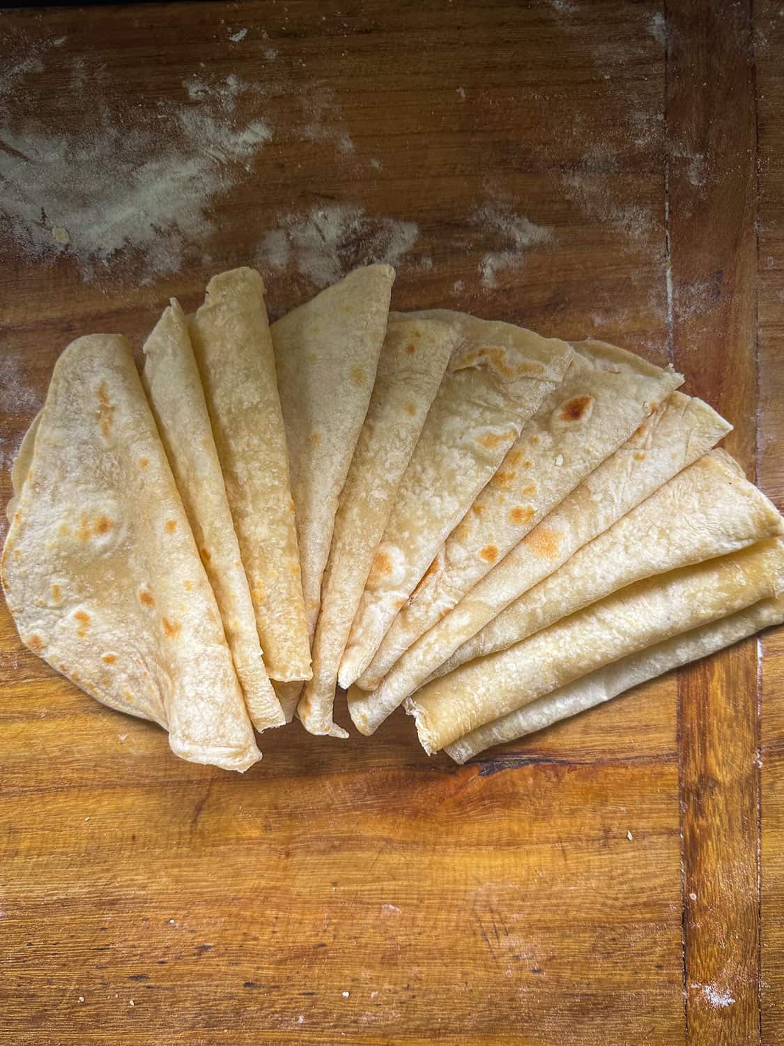 soft flour tortilla folded on wooden board