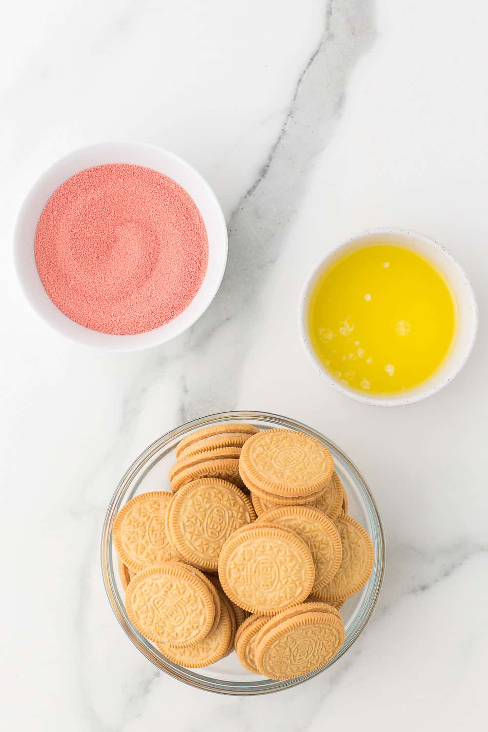 golden oreos, strawberry jello powder, and melted butter in bowls