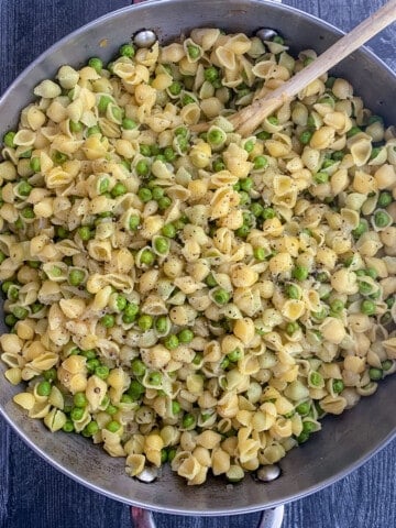 top view of pasta and peas with wooden spoon