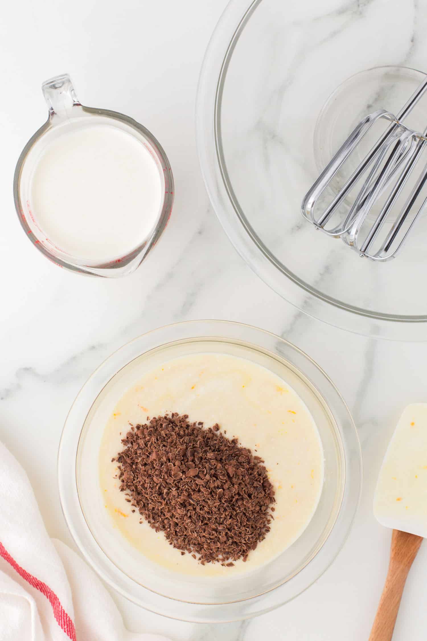 adding grated chocolate into ricotta cream in glass bowl