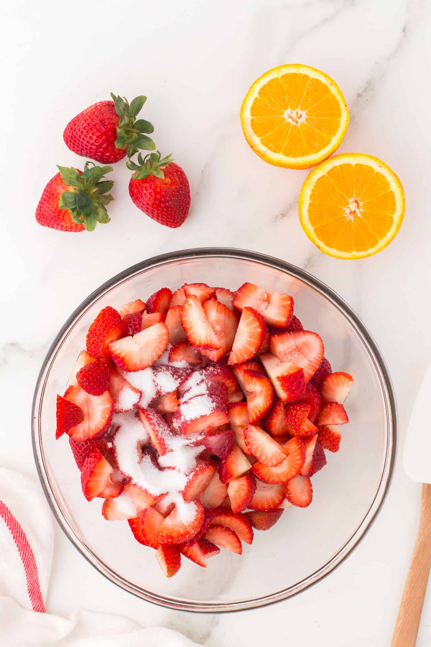 chopped strawberries in glass bowl topped with sugar