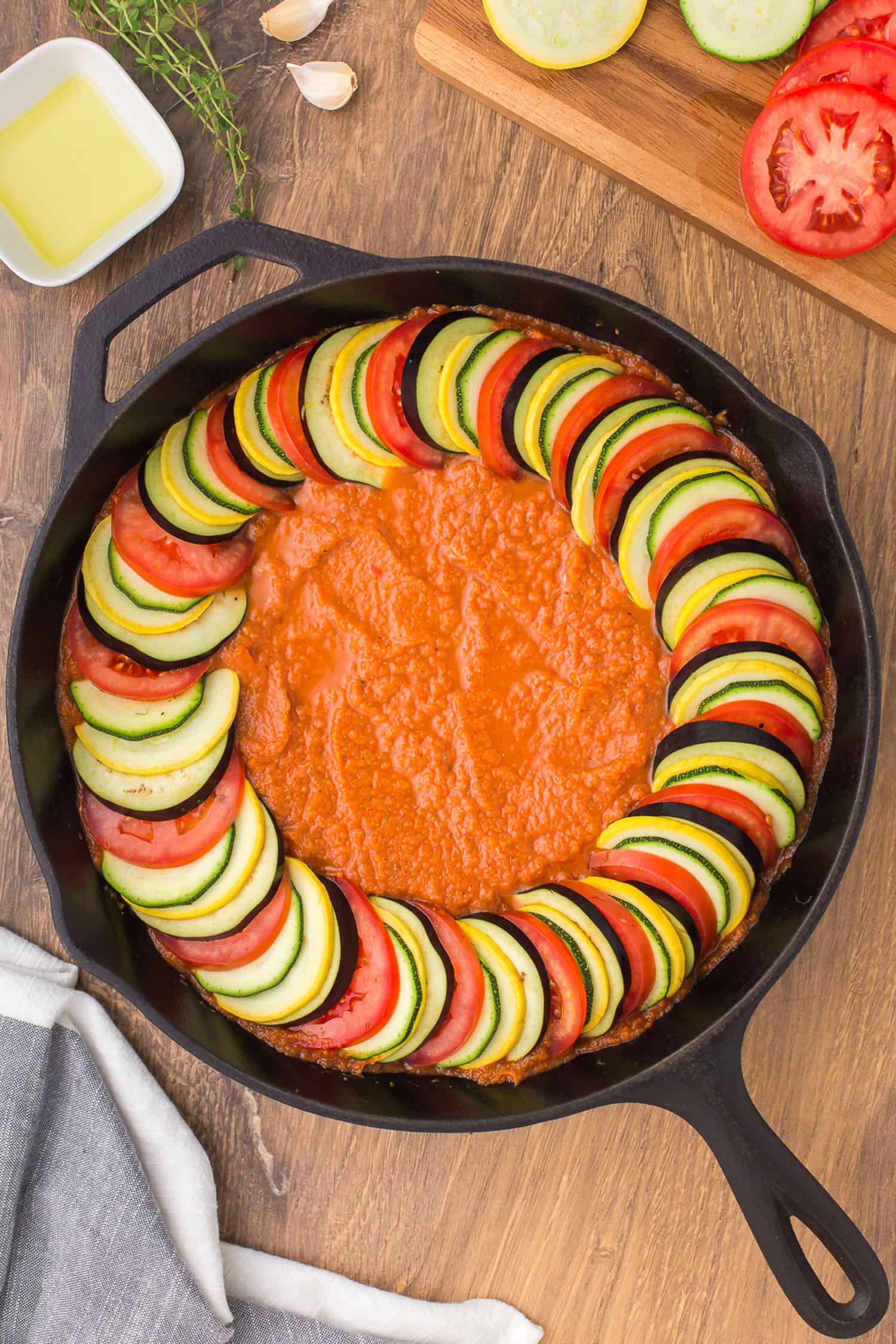 arranging slices of vegetables over puree in pan