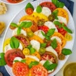 top view of caprese salad on white platter with navy napkin