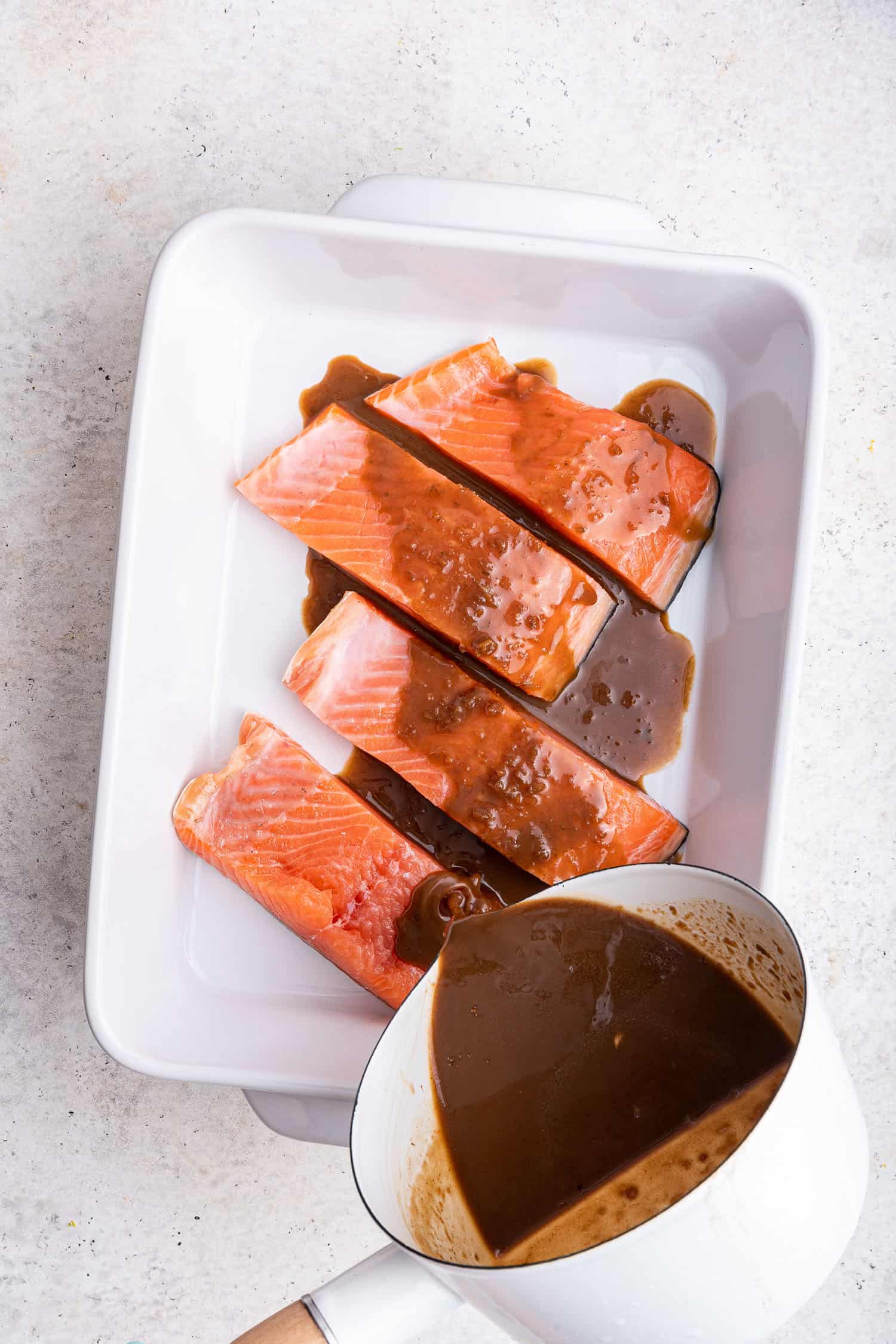pouring sauce on the salmon