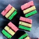 several italian rainbow cookies on black tray