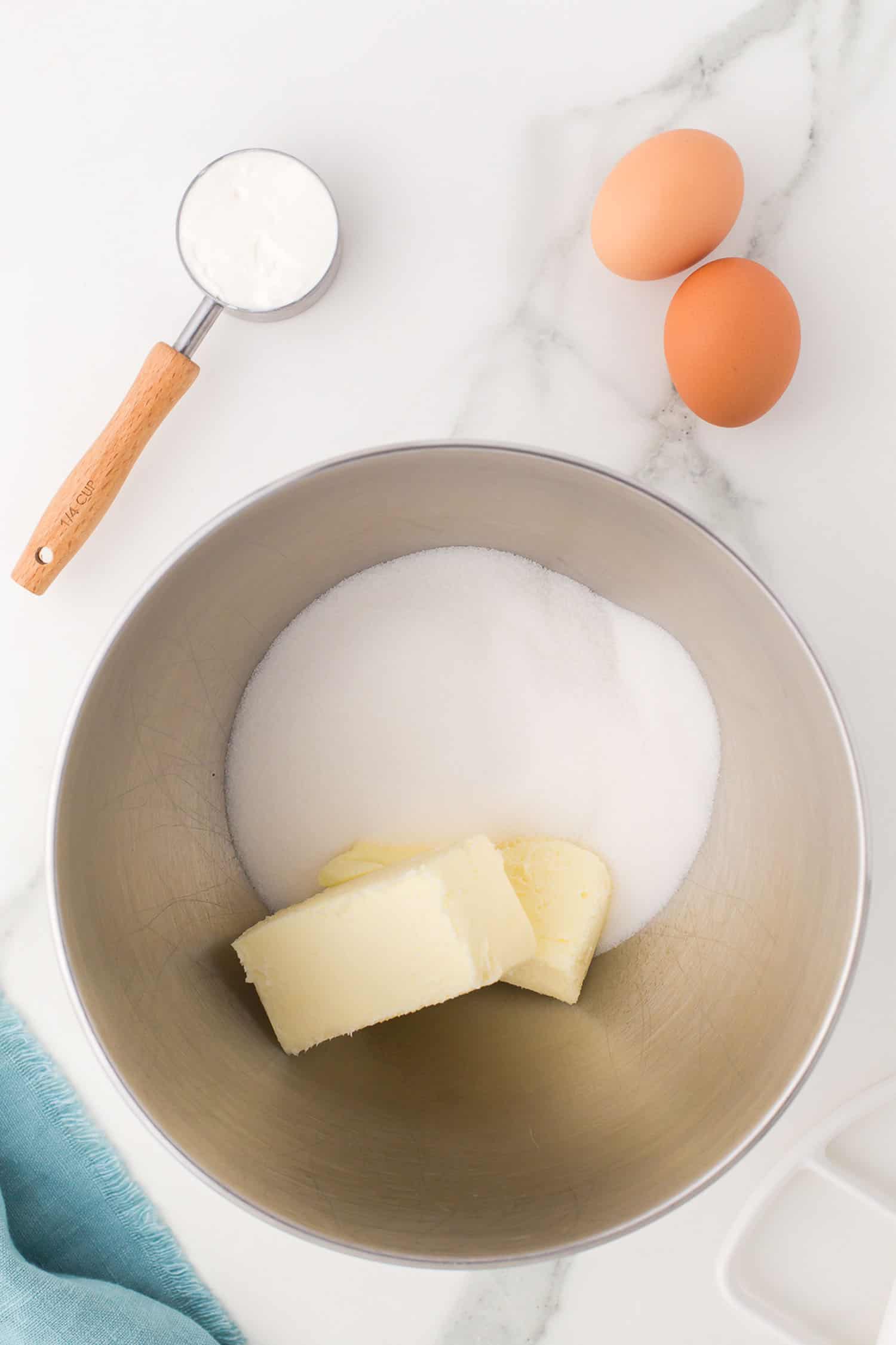 butter and sugar in bowl; eggs and sour cream on the side