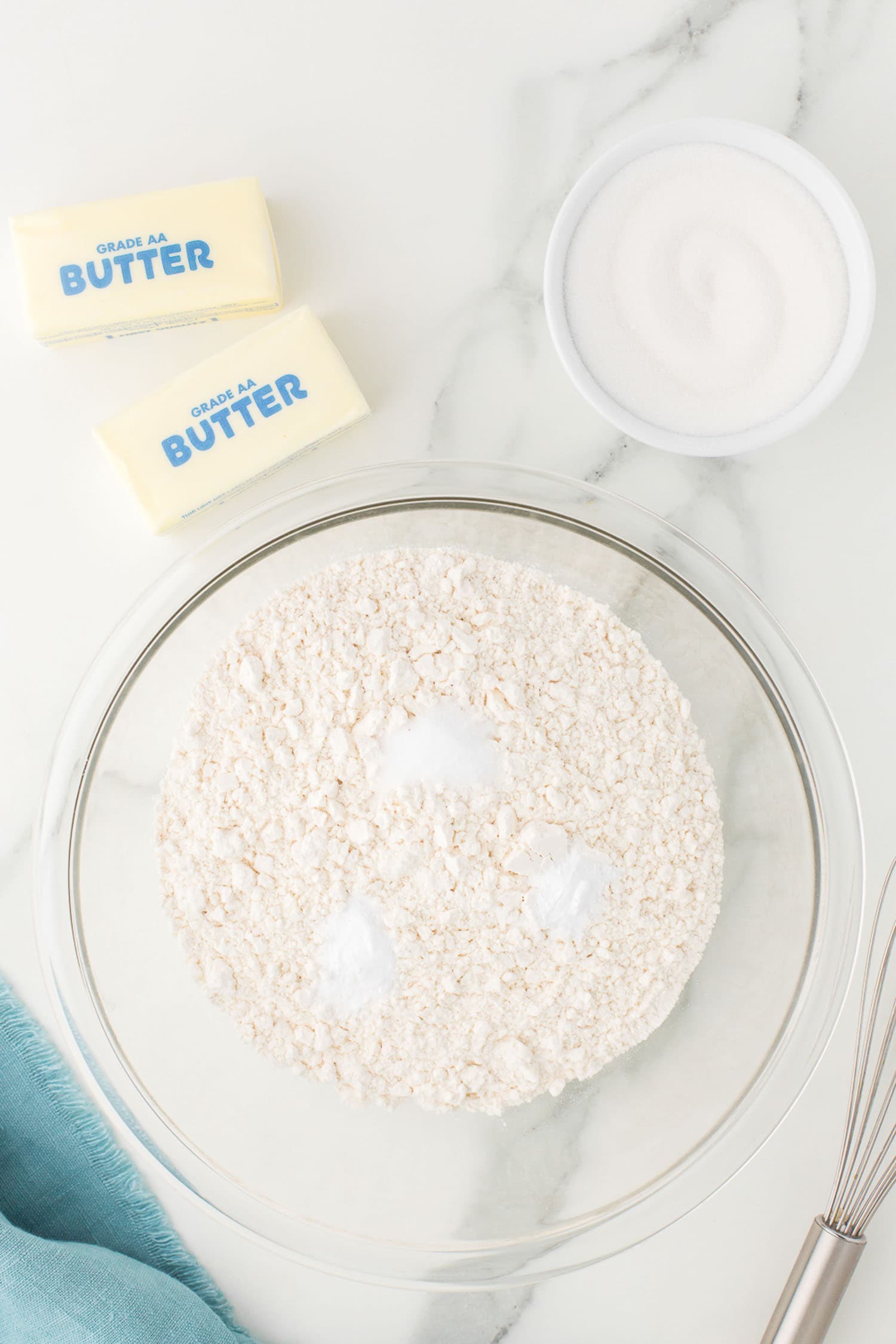 mixing baking soda, baking powder, and salt into flour