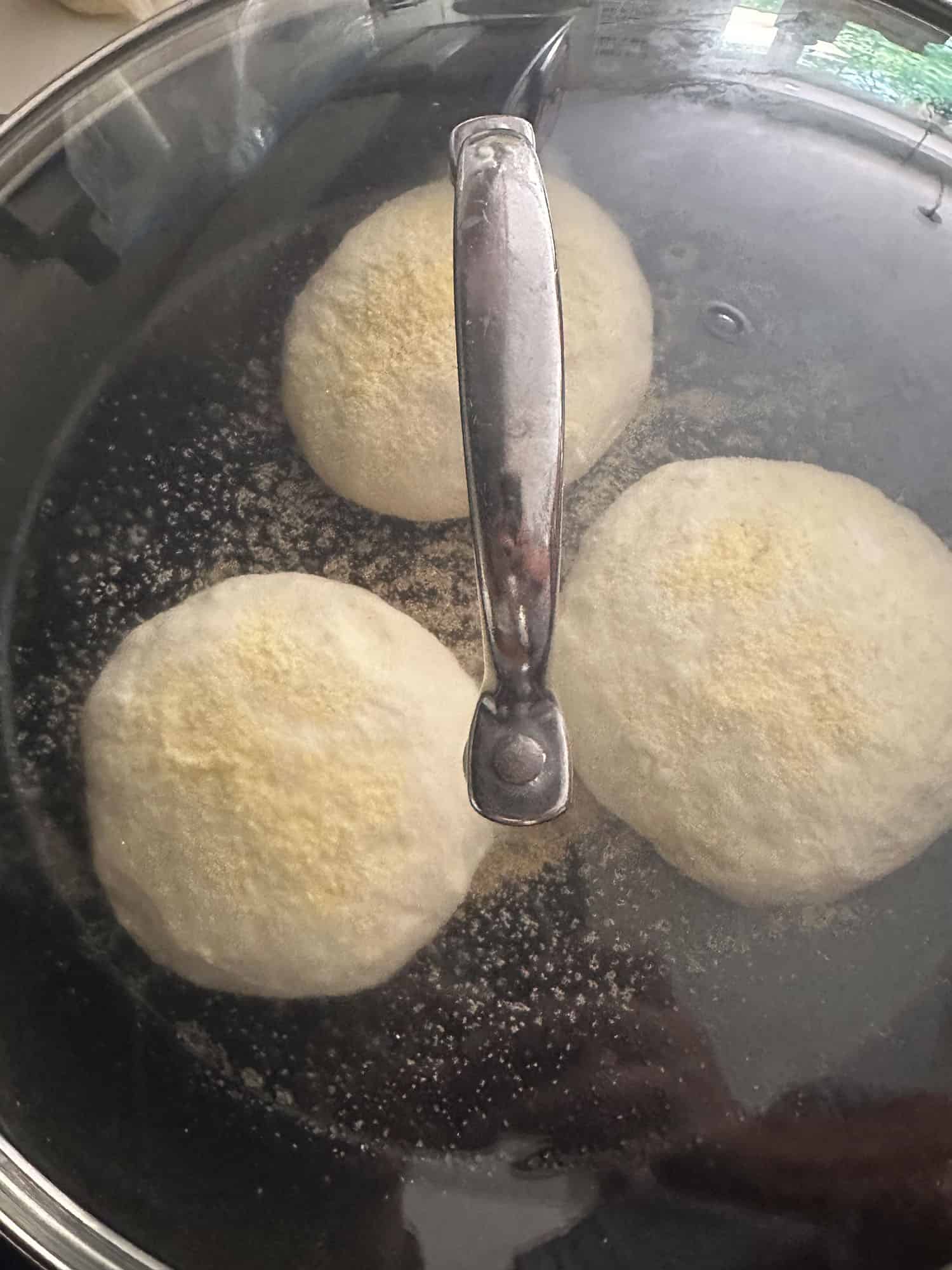 cooking sourdough muffins on stovetop in covered cast iron pan