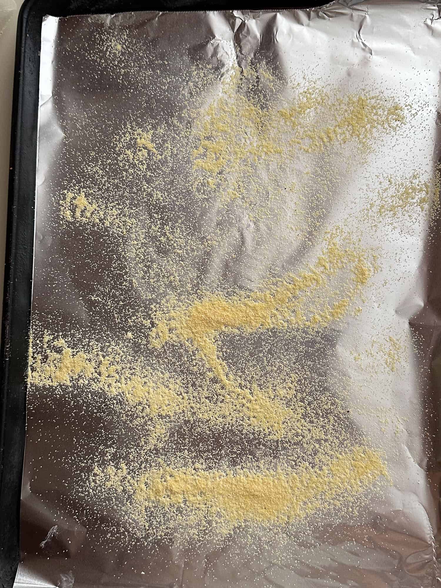 cornmeal sprinkled on baking pan lined with aluminum foil
