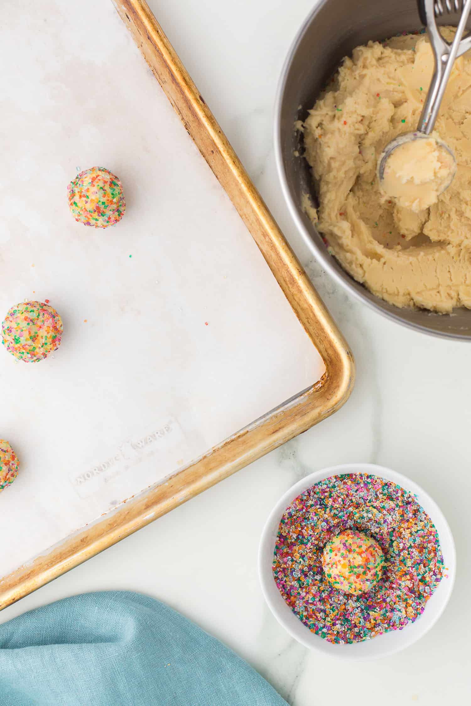 rolling cookie balls in colored sugar