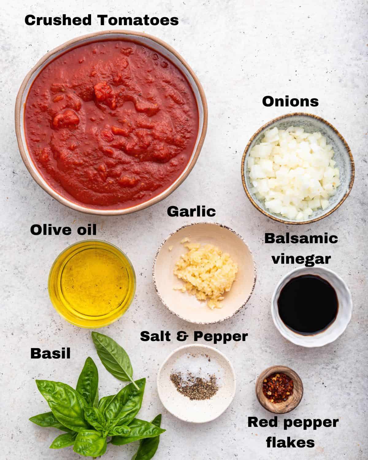 Ingredients for Arrabbiata sauce measured out in cups and dishes.