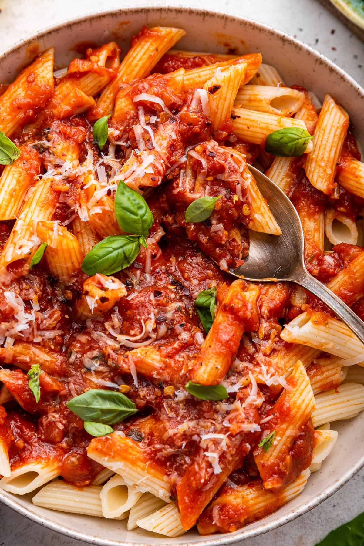 Arrabbiata sauce over penne pasta in white dish.