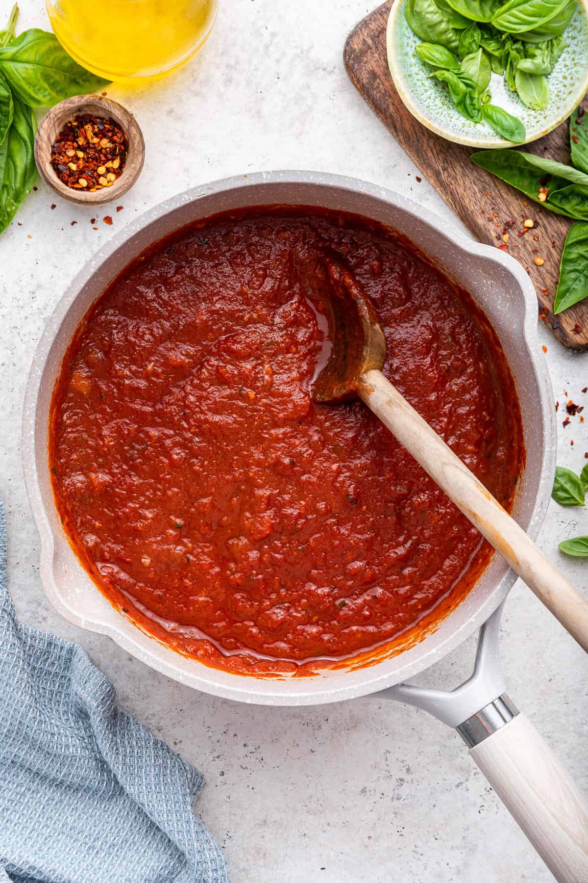 Finished sauce with wooden spoon in white pot.