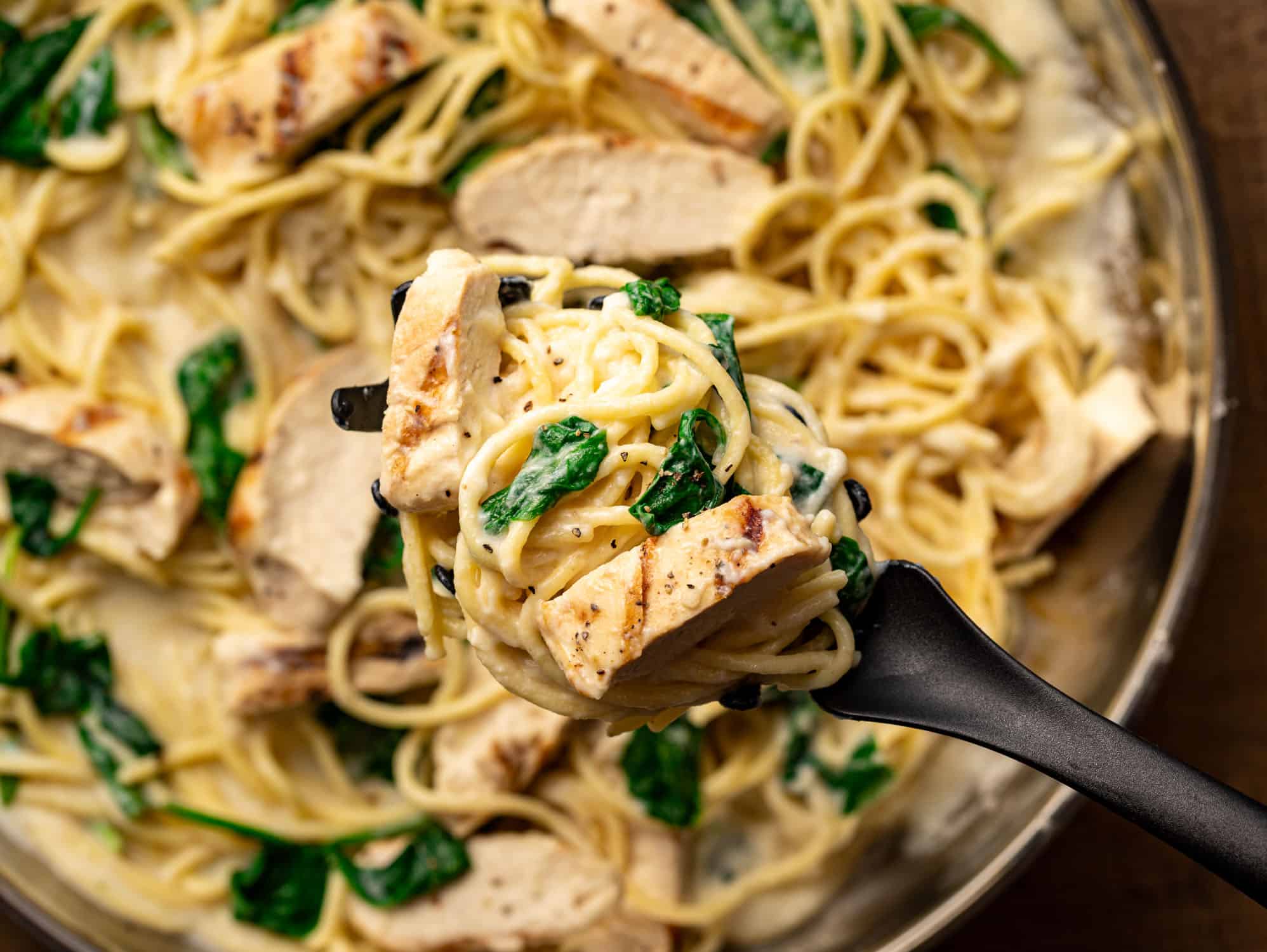 forkful of chicken florentine pasta from pan