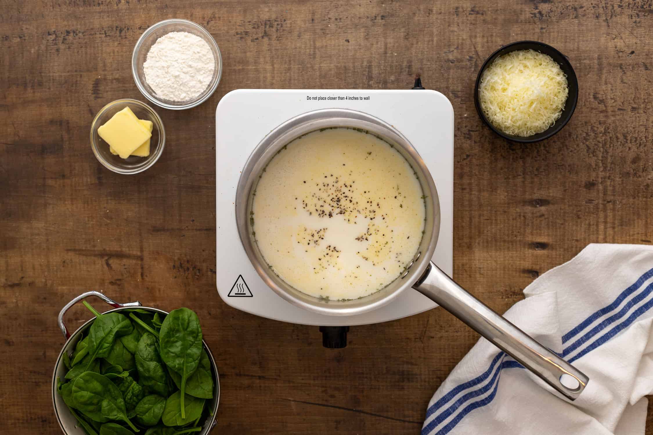 Pot of cream sauce for chicken Florentine. 