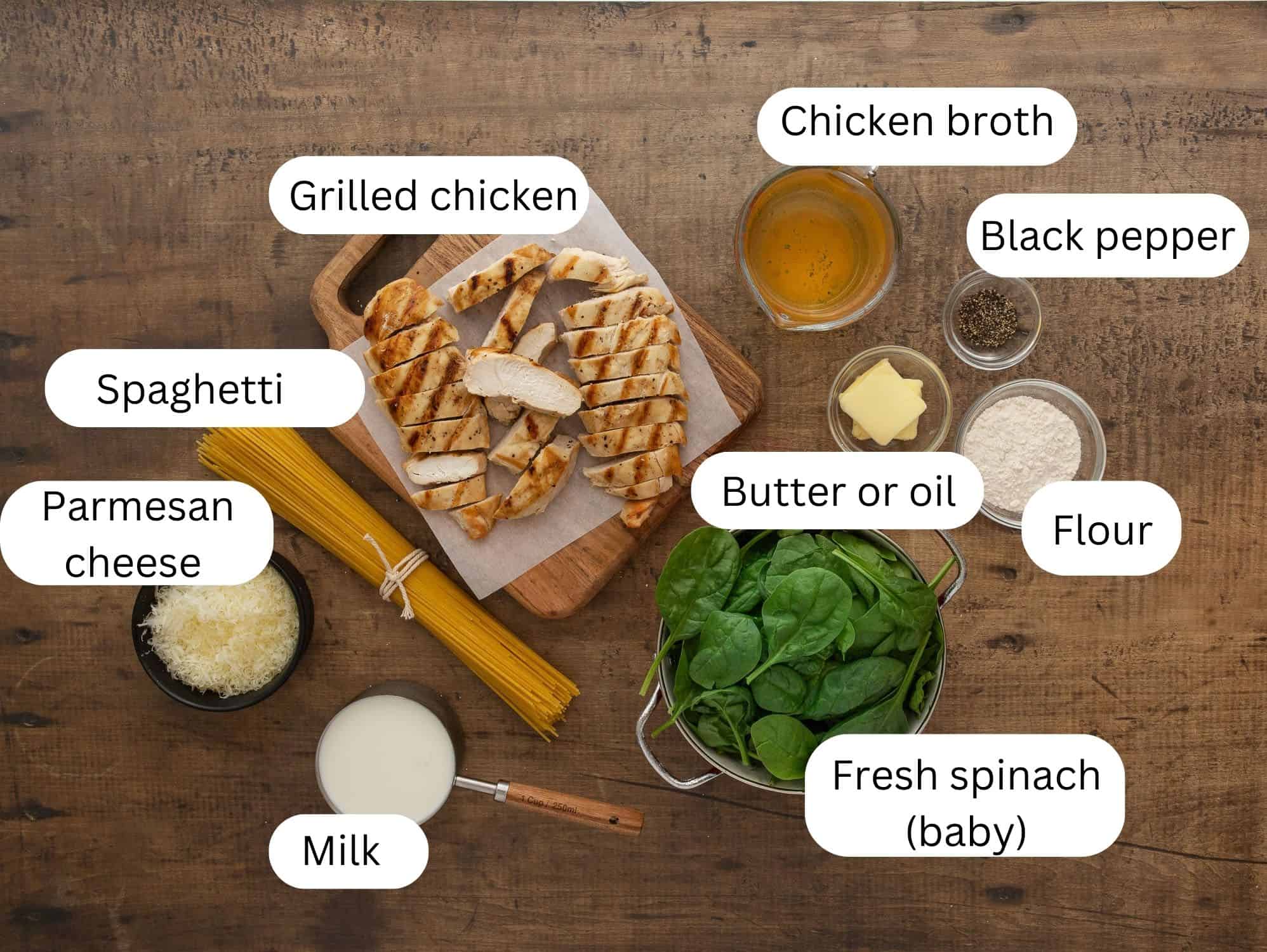 Ingredients for chicken Florentine pasta on a wooden background. 