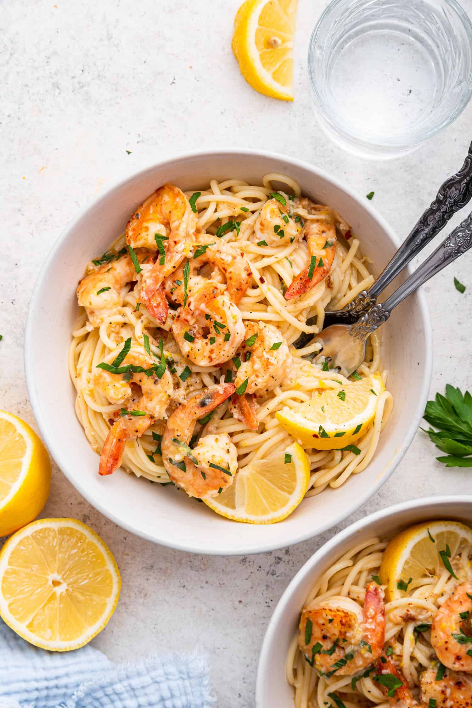 lemon shrimp pasta in white bowl with two forks