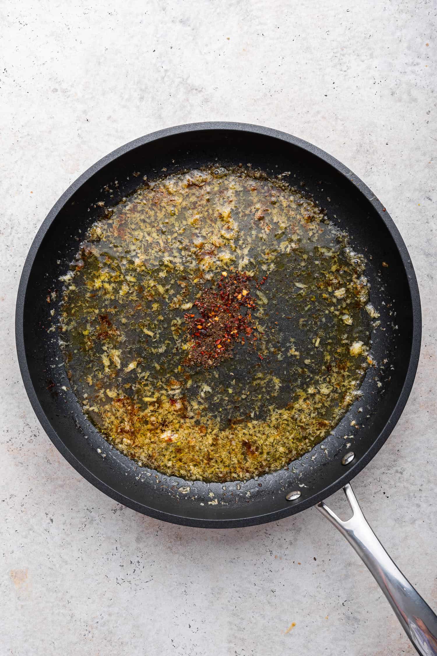 garlic and spices in olive oil in pan