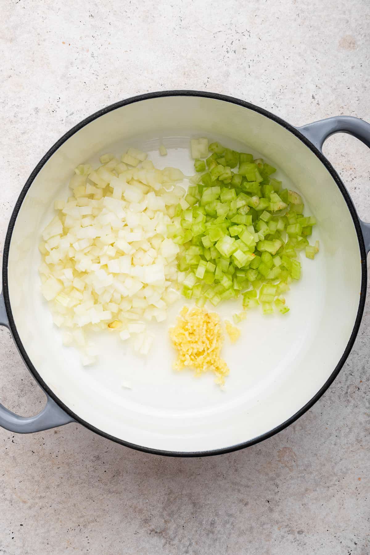 Adding onion, celery and garlic to a large pot.
