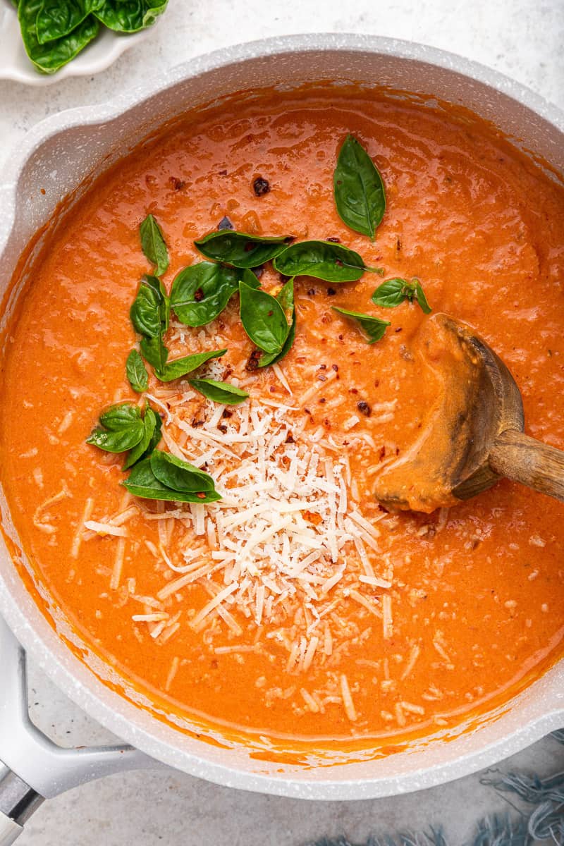 Large bowl of homemade vodka sauce with grated cheese and basil.