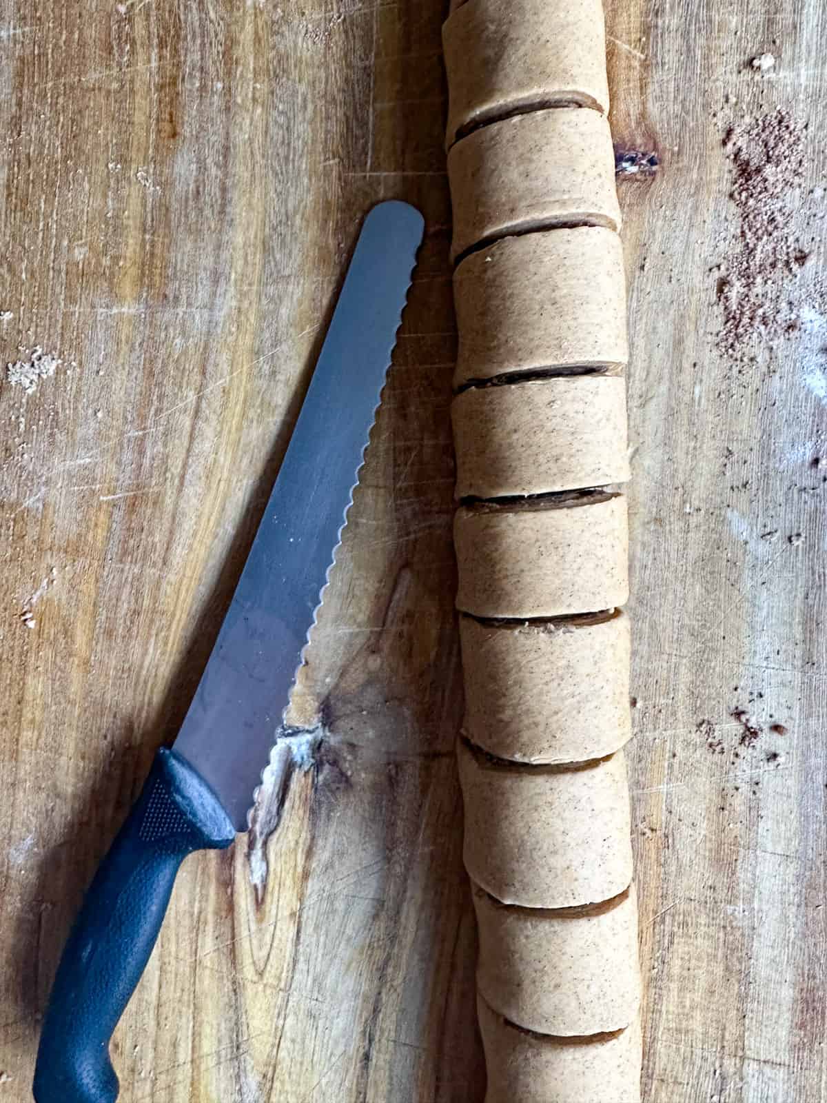 Using a serrated knife to cut the cinnamon rolls. 