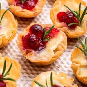 Close up view of cranberry brie bites with rosemary.