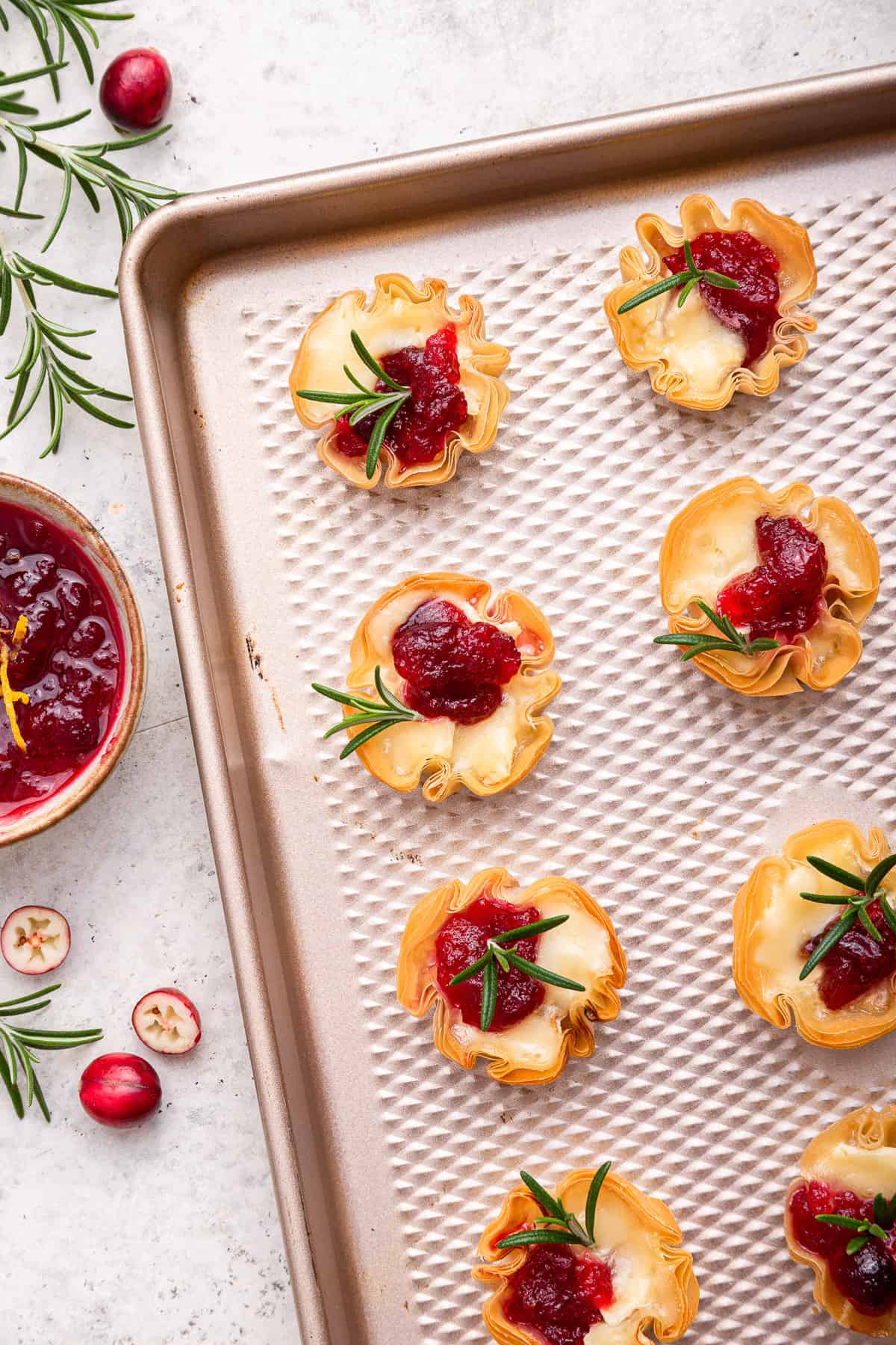 Close up on cranberry brie bites on baking sheet.