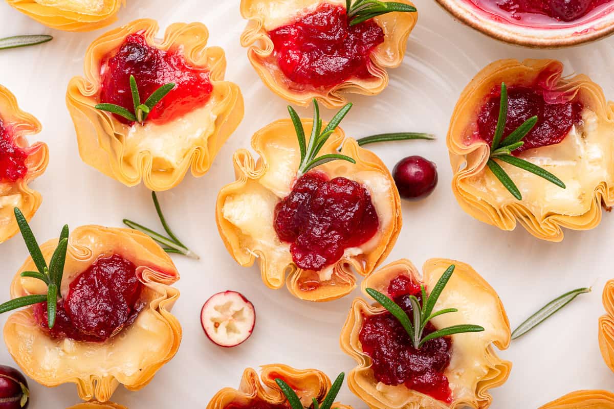 Cranberry bites with brie on white plate.