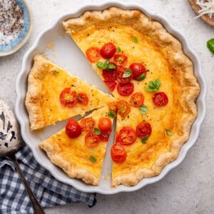 Easy quiche in white dish with slice taken out.