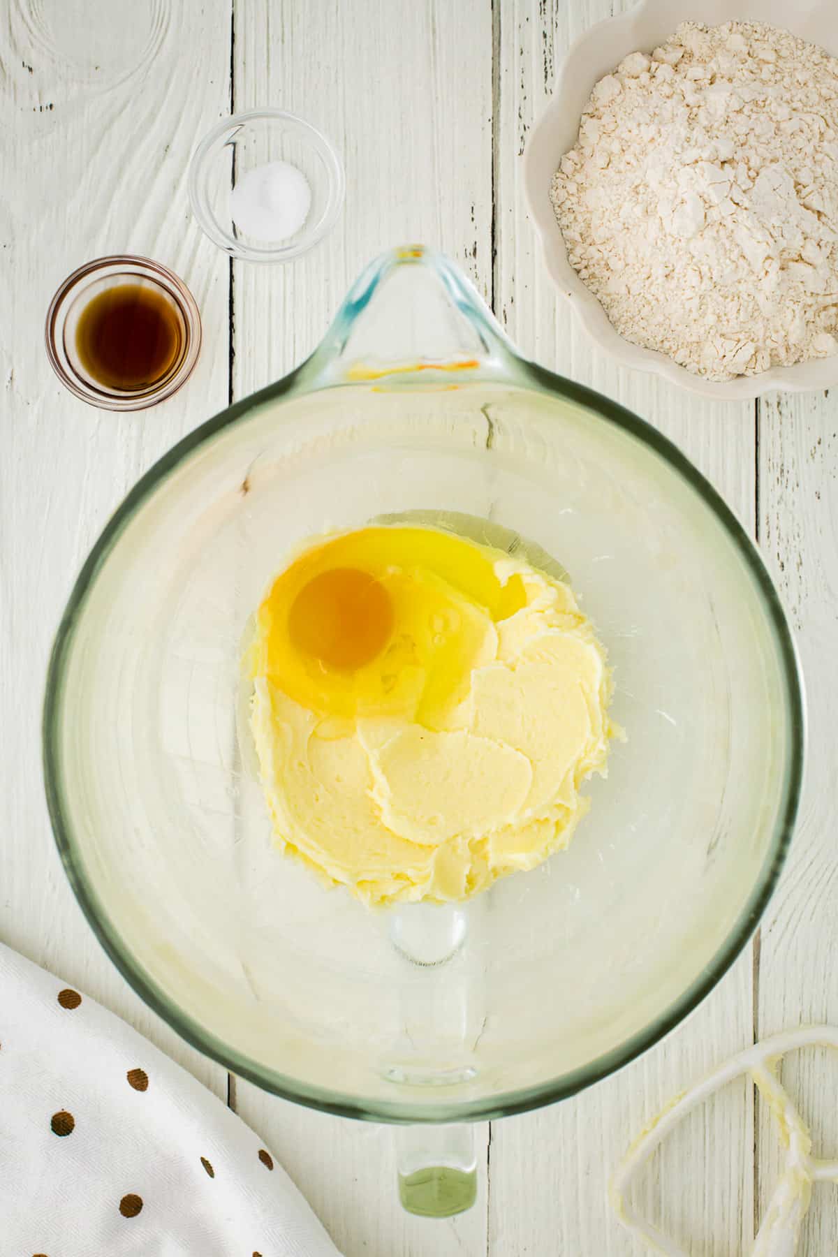 Adding egg to the butter in a glass bowl.
