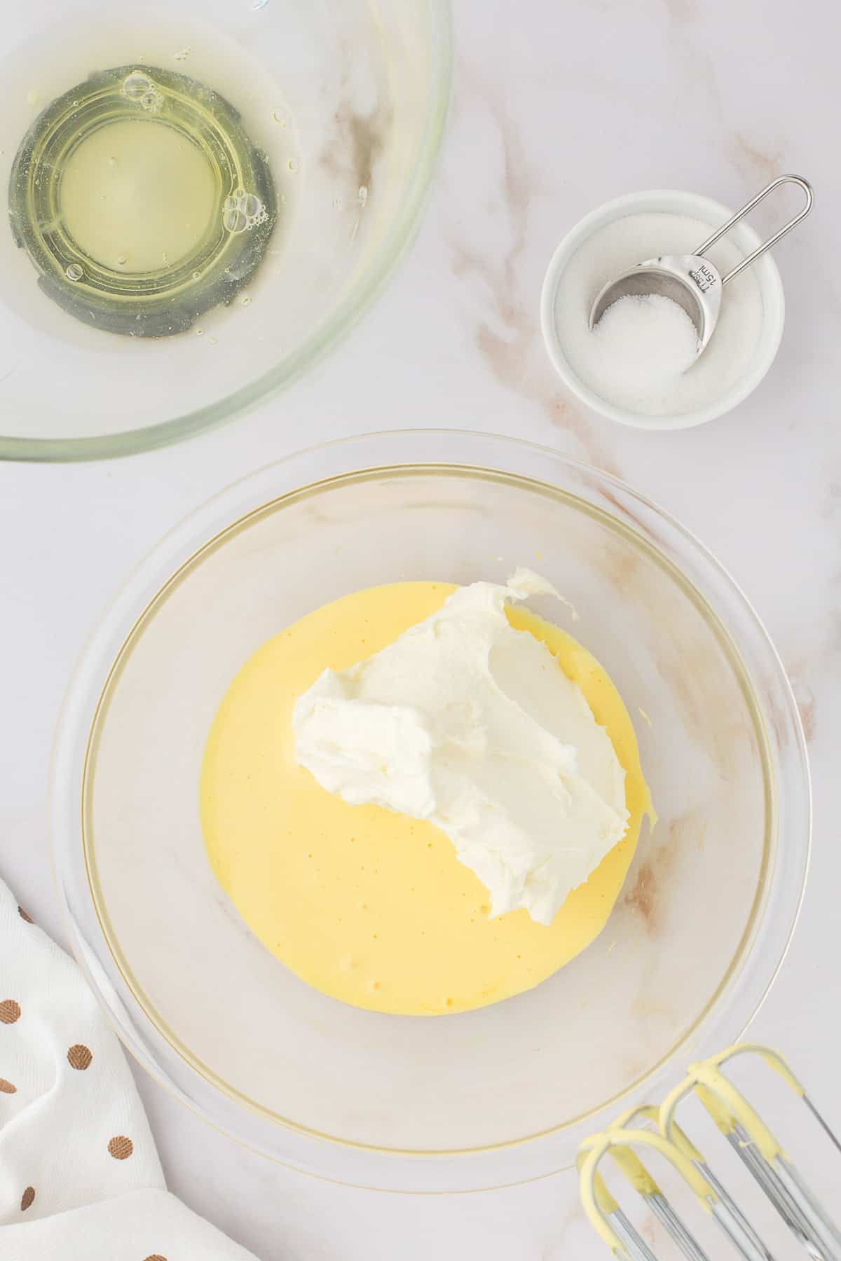Adding whipped egg whites to creamed yolks.
