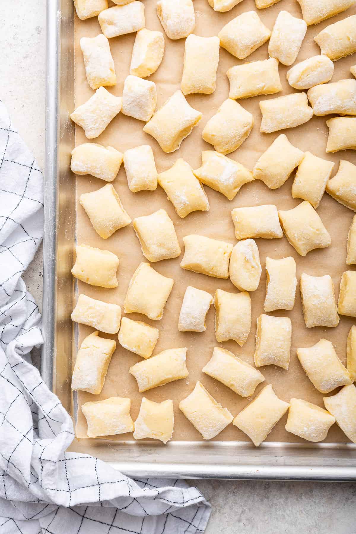 Potato gnocchi on parchment lined baking tray.