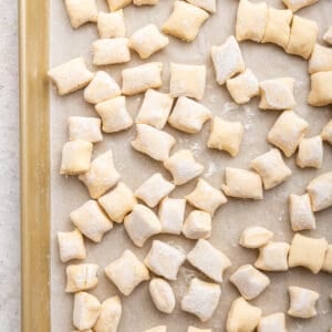 Ricotta gnocchi on parchment lined baking sheet.