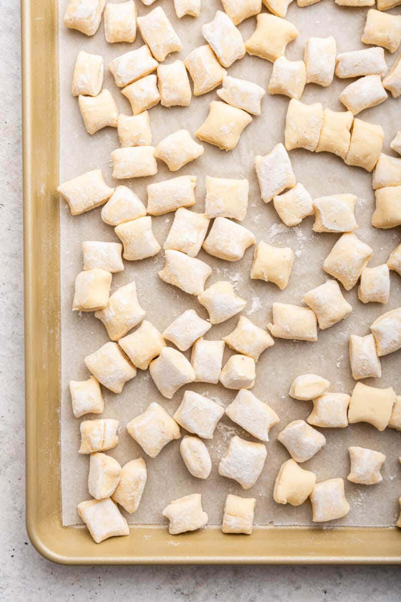 Ricotta gnocchi on parchment lined baking sheet.
