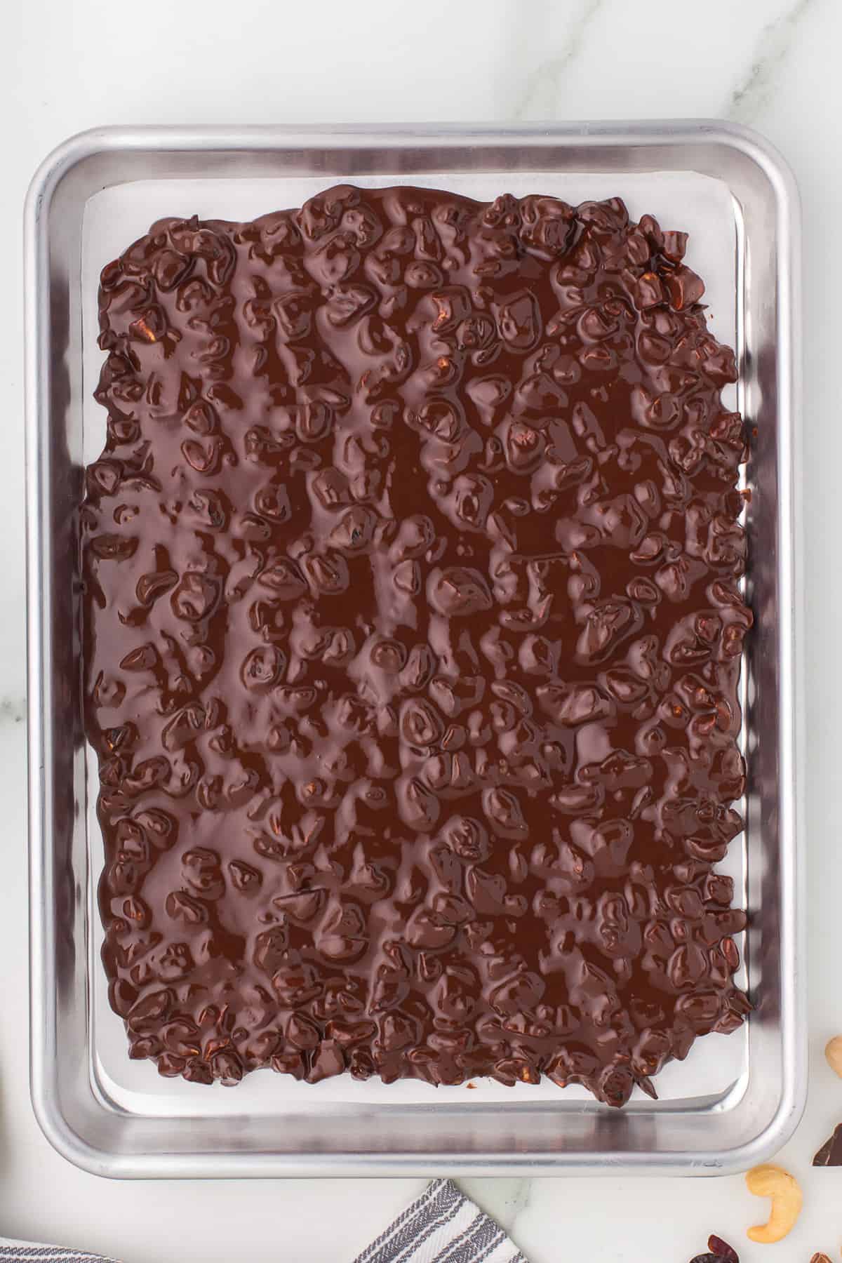 Chocolate bark before setting spread on baking sheet.