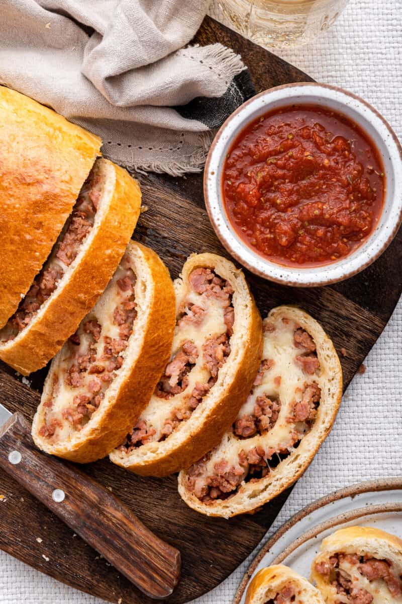 Sausage roll slices with dipping sauce.