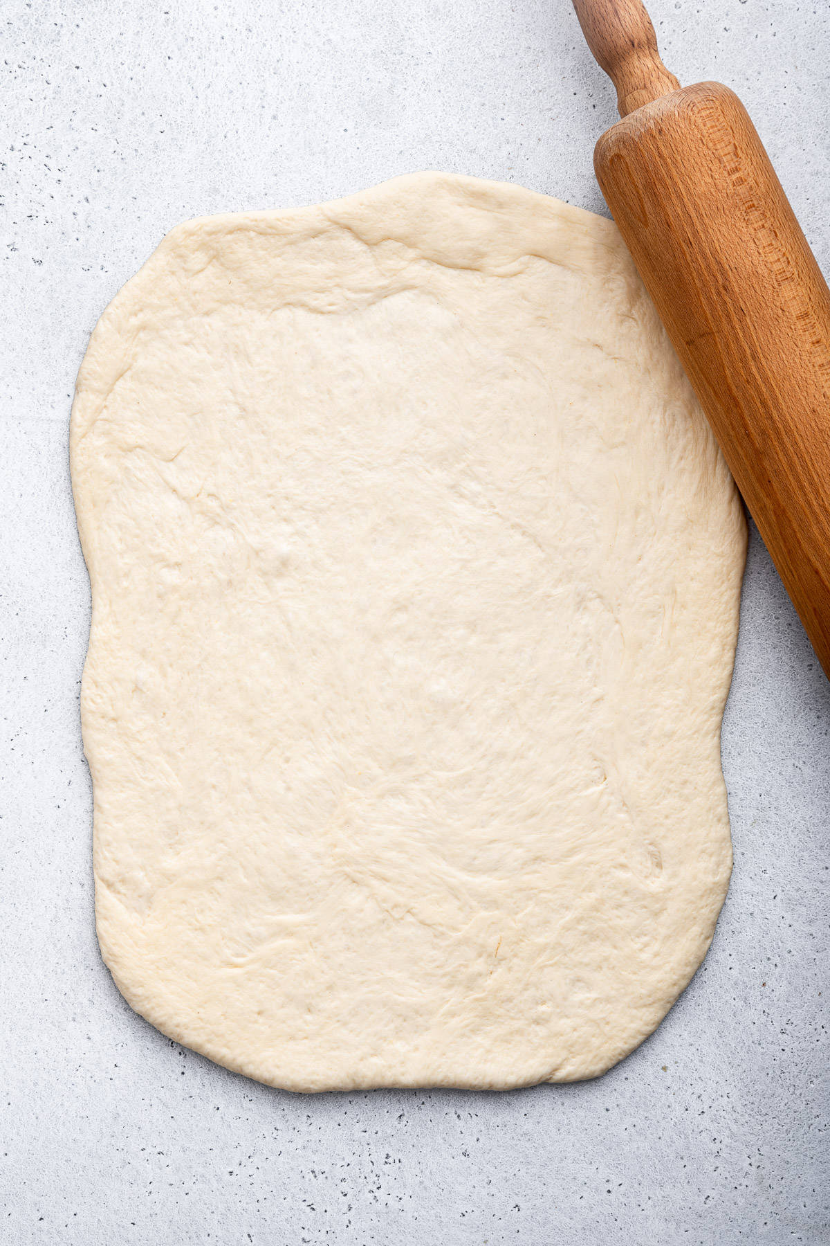 Rolling out bread dough with rolling pin.