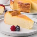 Ricotta cheesecake with berries on white plate.