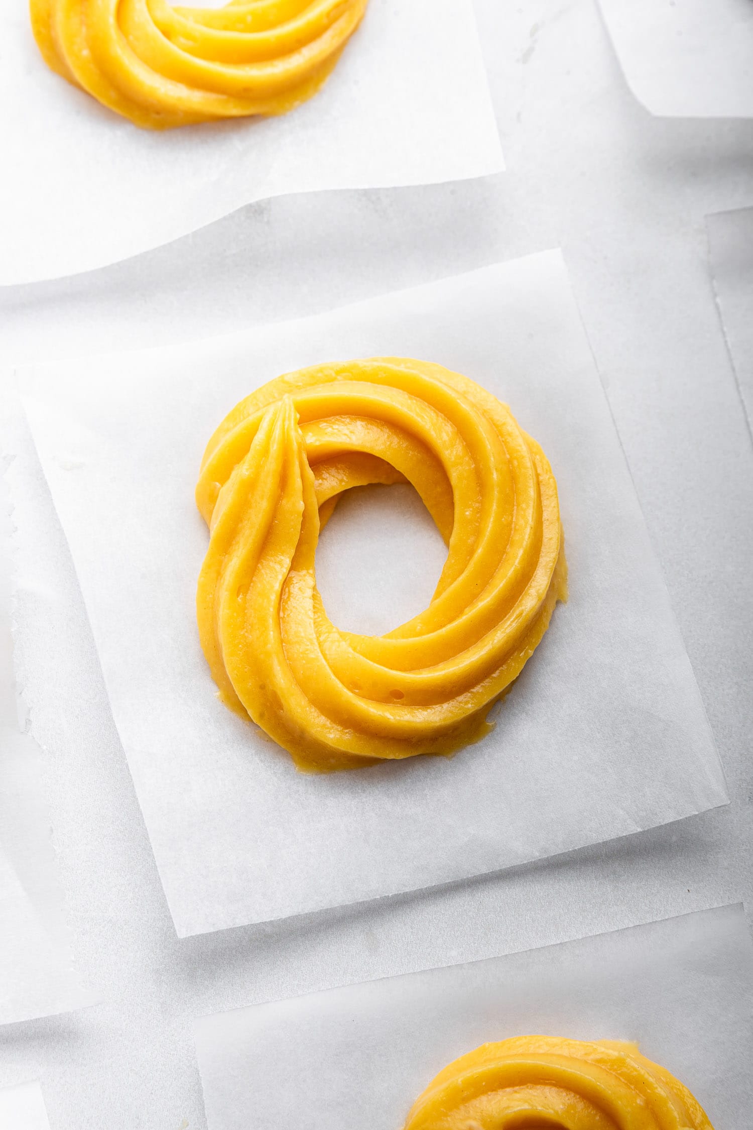 Close up of pastry ring on parchment square.