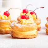 Side view of St Joseph's pastries topped with cherries and filled with pastry cream.