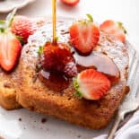 French toast with strawberries and syrup drizzle.