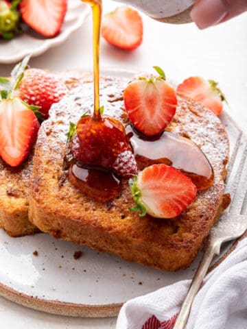 French toast with strawberries and syrup drizzle.