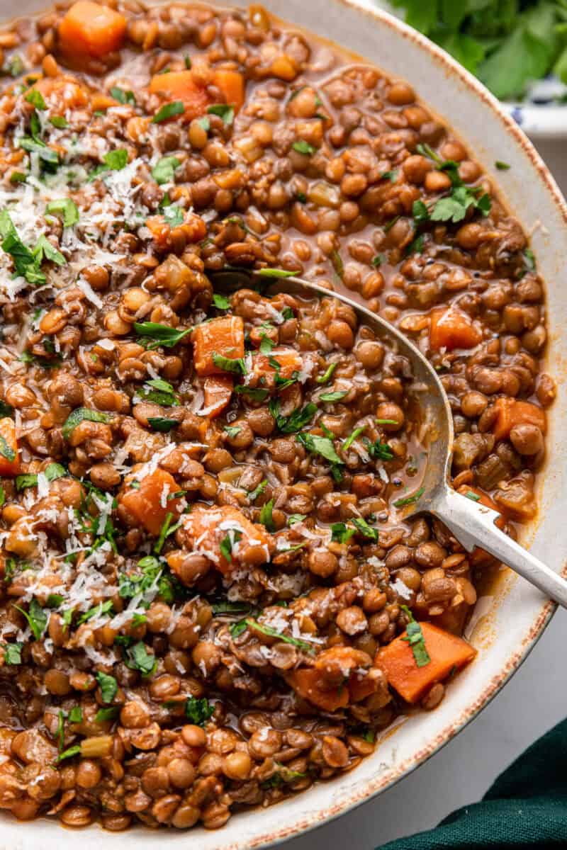 Close view of Italian lentils with serving spoon in large dish.